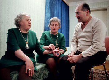 Movie still from “Land of Silence and Darkness” (1971), directed by Werner Herzog – A group of people sitting on a couch; Medium shot, High angle