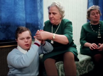 Movie still from “Land of Silence and Darkness” (1971), directed by Werner Herzog – An older woman and a young boy holding hands; Medium shot, High angle