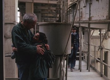 Movie still from “Landscape in the Mist” (1988), directed by Theodoros Angelopoulos – A man and a woman hugging in a building; Wide shot, Over the shoulder angle