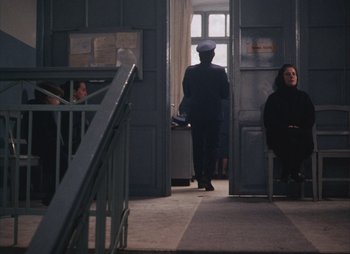 Movie still from “Landscape in the Mist” (1988), directed by Theodoros Angelopoulos – A man in a uniform standing next to a woman; Wide shot, High angle
