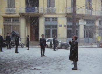 Movie still from “Landscape in the Mist” (1988), directed by Theodoros Angelopoulos – A group of people standing on a street in the snow; Extreme Wide shot, High angle