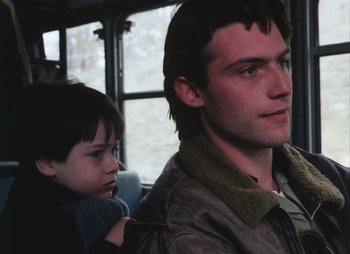 Movie still from “Landscape in the Mist” (1988), directed by Theodoros Angelopoulos – A man and a boy are sitting on a bus together; Close Up shot, Over the shoulder angle