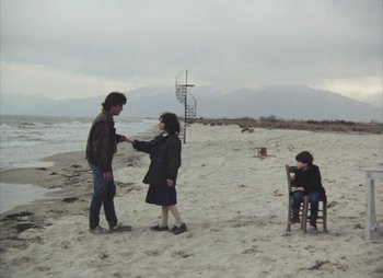 Movie still from “Landscape in the Mist” (1988), directed by Theodoros Angelopoulos – A man and a woman shaking hands on the beach; Wide shot, High angle