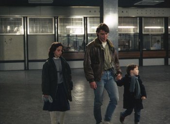 Movie still from “Landscape in the Mist” (1988), directed by Theodoros Angelopoulos – A man and a woman walking with a child; Wide shot, Low angle