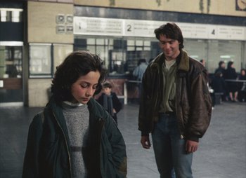 Movie still from “Landscape in the Mist” (1988), directed by Theodoros Angelopoulos – A man and a woman are walking in the street; Medium shot, Over the shoulder angle