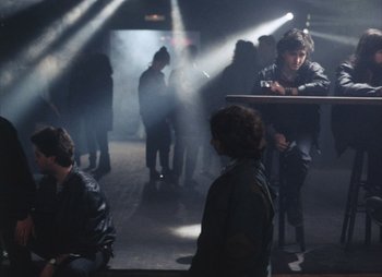 Movie still from “Landscape in the Mist” (1988), directed by Theodoros Angelopoulos – A group of young men standing in a room; Wide shot, High angle