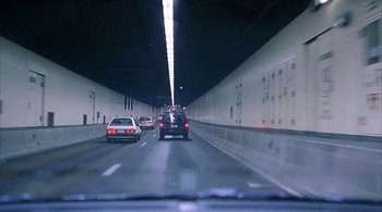 Movie still from “Lantana” (2001), directed by Ray Lawrence – Cars driving down a highway in a tunnel; Extreme Wide shot, High angle