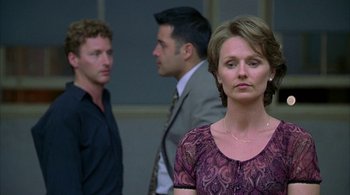 Movie still from “Lantana” (2001), directed by Ray Lawrence – A woman standing in front of two other men; Medium shot, Over the shoulder angle