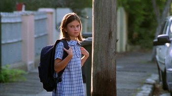 Movie still from “Lantana” (2001), directed by Ray Lawrence – A young girl in a school uniform with a backpack; Medium shot, Low angle