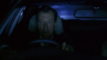 Movie still from “Lantana” (2001), directed by Ray Lawrence – A man sitting in the drivers seat of a car at night; Close Up shot, Low angle