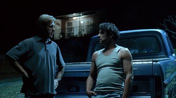 Movie still from “Lantana” (2001), directed by Ray Lawrence – Two men standing next to each other in front of a truck; Medium shot, Low angle