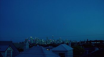 Movie still from “Lantana” (2001), directed by Ray Lawrence – A view of a city skyline at night from a roof top; Extreme Wide shot, High angle