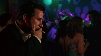 Movie still from “Lantana” (2001), directed by Ray Lawrence – A man smoking a cigarette in front of a crowd of onlookers; Close Up shot, Low angle