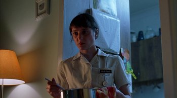Movie still from “Lantana” (2001), directed by Ray Lawrence – A woman holding a pan in a room; Close Up shot, Low angle
