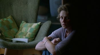 Movie still from “Lantana” (2001), directed by Ray Lawrence – A woman sitting on a chair in a living room; Medium shot, Over the shoulder angle