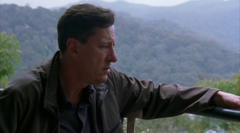 Movie still from “Lantana” (2001), directed by Ray Lawrence – A person sitting on a chair near a forest; Close Up shot, Over the shoulder angle