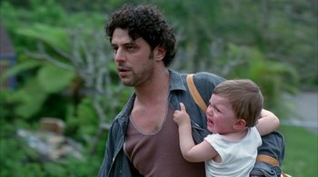 Movie still from “Lantana” (2001), directed by Ray Lawrence – A man holding a crying child while walking down a street; Medium shot, Over the shoulder angle