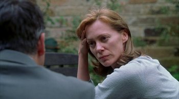 Movie still from “Lantana” (2001), directed by Ray Lawrence – A woman sitting in front of a man with her hand on her head; Close Up shot, Over the shoulder angle