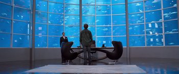 Movie still from “We're the Millers” (2013), directed by Rawson Marshall Thurber – A man standing in front of an aquarium; Wide shot, Over the shoulder angle