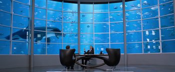 Movie still from “We're the Millers” (2013), directed by Rawson Marshall Thurber – Two men sitting at a table in front of a large aquarium; Wide shot, Over the shoulder angle