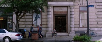 Movie still from “We're the Millers” (2013), directed by Rawson Marshall Thurber – A woman sitting on the steps of a building on the sidewalk; Wide shot, Over the shoulder angle