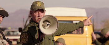Movie still from “We're the Millers” (2013), directed by Rawson Marshall Thurber – A man holding a megaphone while wearing a hat; Medium shot, Over the shoulder angle
