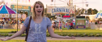 Movie still from “We're the Millers” (2013), directed by Rawson Marshall Thurber – A woman standing in front of a carnival area; Medium shot, Over the shoulder angle