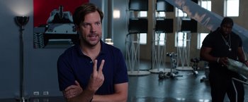 Movie still from “We're the Millers” (2013), directed by Rawson Marshall Thurber – A man in a blue shirt is giving a peace sign; Medium shot, Over the shoulder angle
