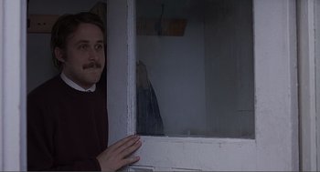 Movie still from “Lars and the Real Girl” (2007), directed by Craig Gillespie – A man standing in front of an open window; Medium shot, Over the shoulder angle