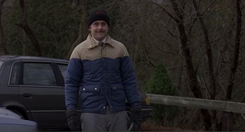 Movie still from “Lars and the Real Girl” (2007), directed by Craig Gillespie – A man standing next to a car in a wooded area; Medium shot, Low angle