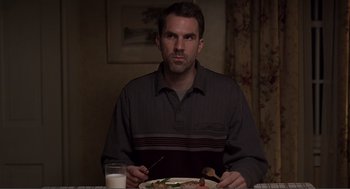 Movie still from “Lars and the Real Girl” (2007), directed by Craig Gillespie – A man sitting at a table with a plate of food in front of him; Medium shot, Over the shoulder angle