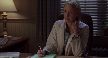 Movie still from “Lars and the Real Girl” (2007), directed by Craig Gillespie – A woman sitting at a table writing on a piece of paper; Medium shot, Over the shoulder angle