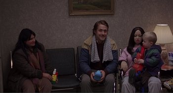 Movie still from “Lars and the Real Girl” (2007), directed by Craig Gillespie – A man sitting in a waiting room next to two other people; Medium shot, Low angle