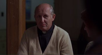 Movie still from “Lars and the Real Girl” (2007), directed by Craig Gillespie – An older man wearing a priest's outfit; Close Up shot, Low angle