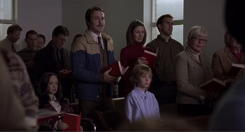 Movie still from “Lars and the Real Girl” (2007), directed by Craig Gillespie – A group of people standing in front of a window holding books; Medium shot, Low angle