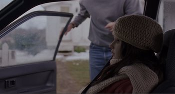 Movie still from “Lars and the Real Girl” (2007), directed by Craig Gillespie – A woman sitting in the back of a car while a man stands next to it; Medium shot, Over the shoulder angle