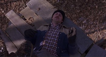 Movie still from “Lars and the Real Girl” (2007), directed by Craig Gillespie – A man laying on the ground in the woods; Wide shot, Overhead angle