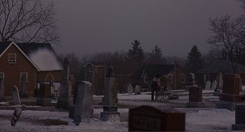 Movie still from “Lars and the Real Girl” (2007), directed by Craig Gillespie – Two people on a bike in a cemetery; Extreme Wide shot, High angle