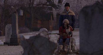 Movie still from “Lars and the Real Girl” (2007), directed by Craig Gillespie – A man and woman in a wheelchair in a field; Wide shot, High angle