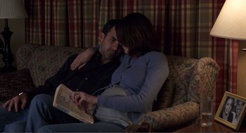 Movie still from “Lars and the Real Girl” (2007), directed by Craig Gillespie – A man and a woman sitting on a couch reading a book; Medium shot, High angle