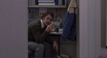 Movie still from “Lars and the Real Girl” (2007), directed by Craig Gillespie – A man sitting on a chair eating a donut; Wide shot, Over the shoulder angle