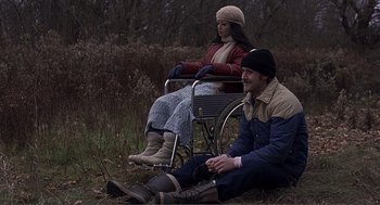 Movie still from “Lars and the Real Girl” (2007), directed by Craig Gillespie – A man and a woman sitting on a chair in a field; Wide shot, High angle