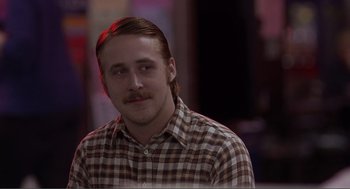 Movie still from “Lars and the Real Girl” (2007), directed by Craig Gillespie – A man with long hair and a mustache is wearing a checkered shirt; Close Up shot, Over the shoulder angle