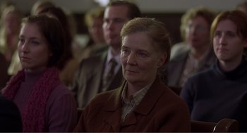 Movie still from “Lars and the Real Girl” (2007), directed by Craig Gillespie – An older woman is sitting in front of a group of people; Close Up shot, Over the shoulder angle