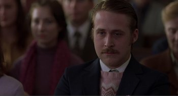 Movie still from “Lars and the Real Girl” (2007), directed by Craig Gillespie – A man in a suit and tie with a mustache; Close Up shot, Over the shoulder angle