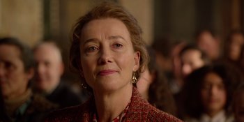 Movie still from “Last Christmas” (2019), directed by Paul Feig – An older woman wearing a red jacket and gold earrings; Close Up shot, Over the shoulder angle
