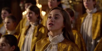 Movie still from “Last Christmas” (2019), directed by Paul Feig – A group of young people singing in front of a crowd; Close Up shot, Over the shoulder angle