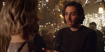 Movie still from “Last Christmas” (2019), directed by Paul Feig – A man holding a glass of wine talking to a woman; Close Up shot, Over the shoulder angle