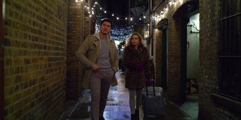 Movie still from “Last Christmas” (2019), directed by Paul Feig – A man and a woman are standing in the street; Wide shot, Low angle