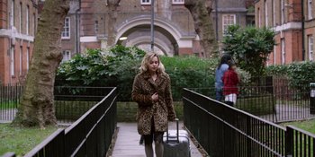 Movie still from “Last Christmas” (2019), directed by Paul Feig – A woman walking down a sidewalk with a suitcase; Wide shot, High angle